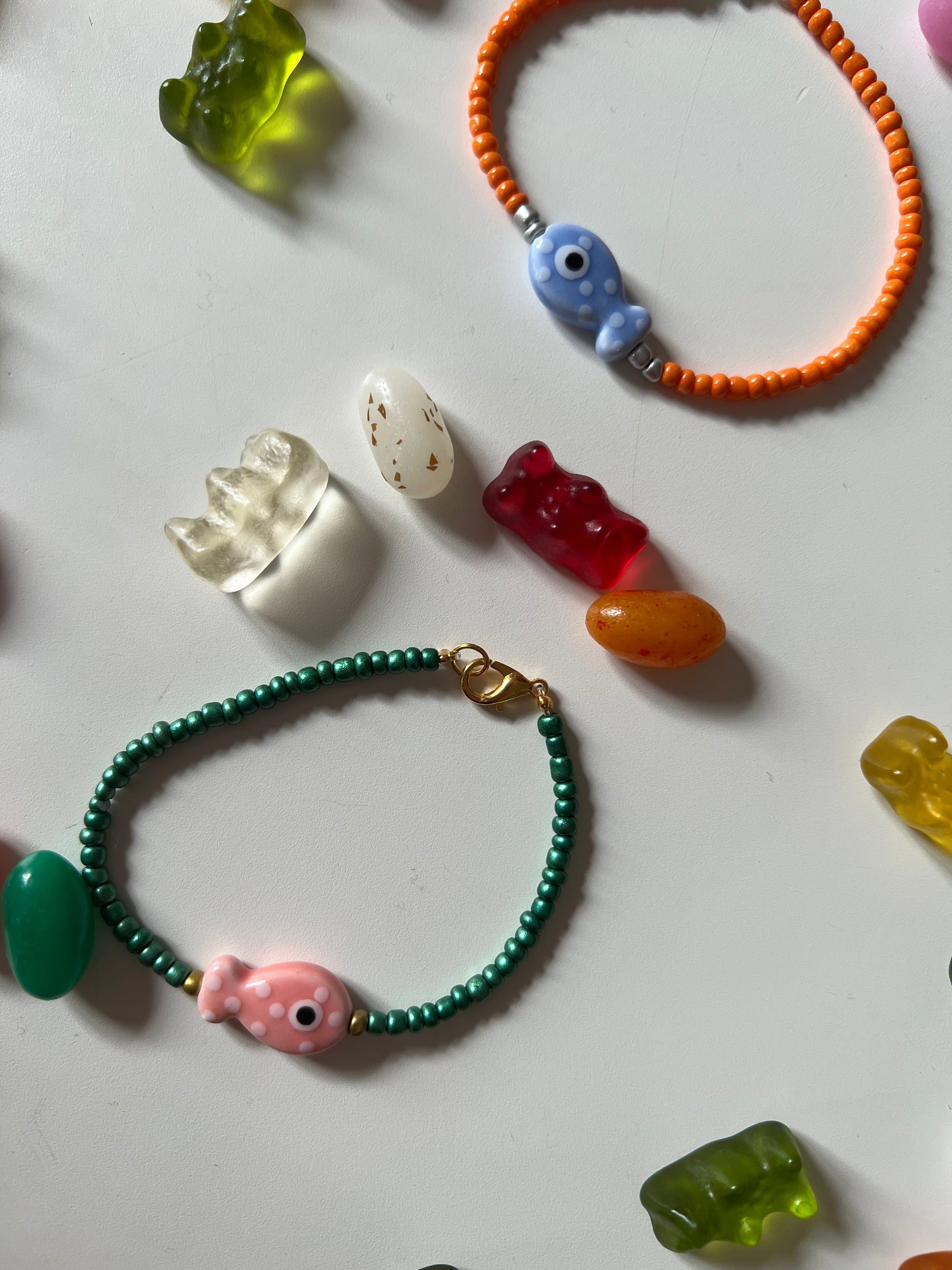 Bird's Eye View of Bracelets . Featuring Ceramic Fish Beads in a Variety of orange and blue fish and green and pink fish