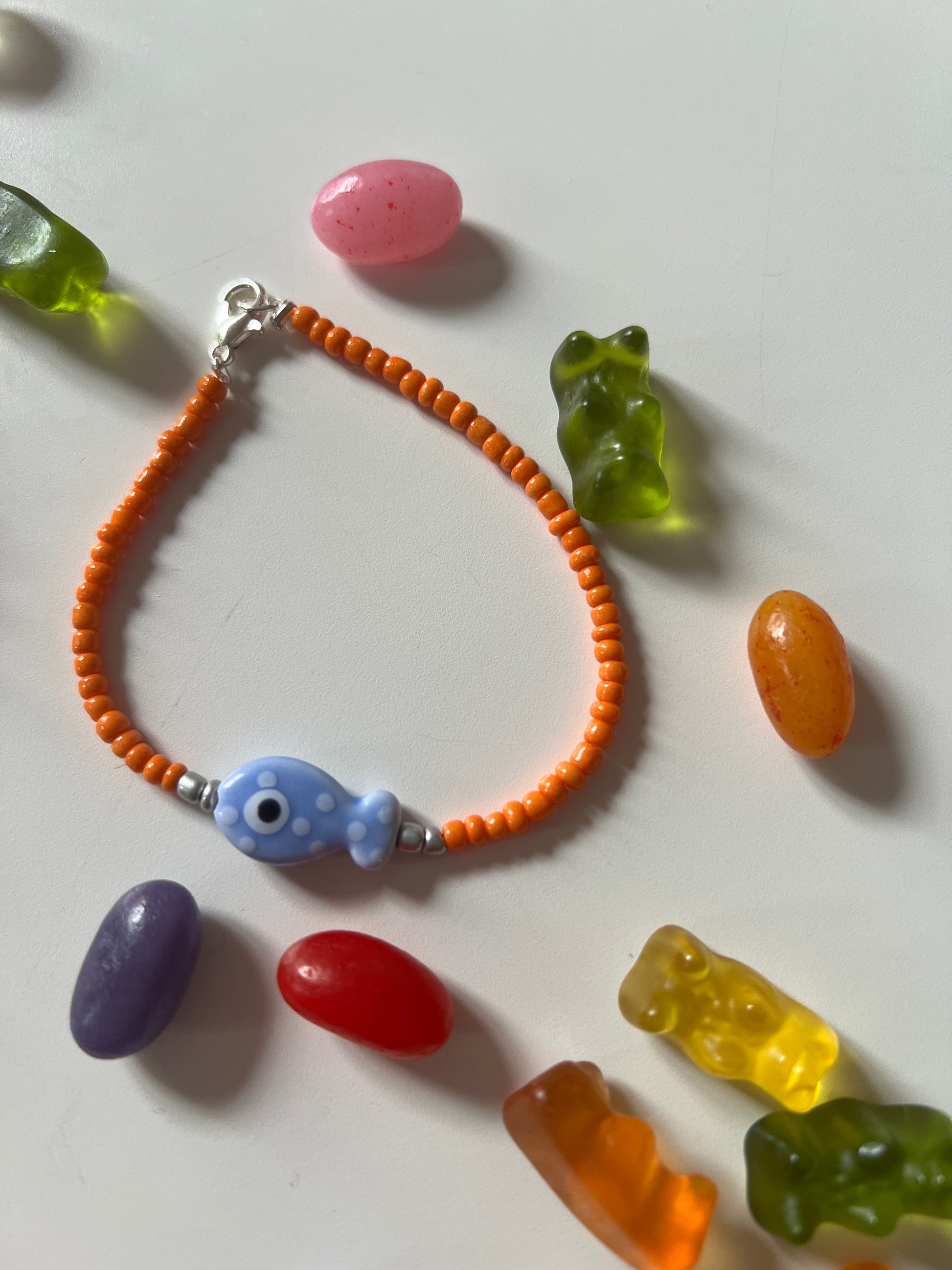 Bird's Eye View of Bracelets . Featuring Ceramic Fish Beads in blue fish and orange beads